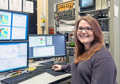 Katrina Deane sitzt vor Computern am Setup