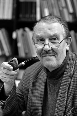 Black-and-white portrait of the older Henning Scheich wearing glasses and holding a pipe.