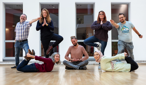 Mitglieder der AG in verschiedenen Yoga-Positionen im Atrium